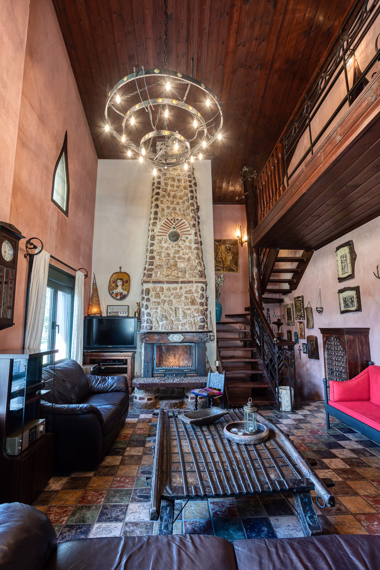 Double-height living room with chandelier and stone chimney